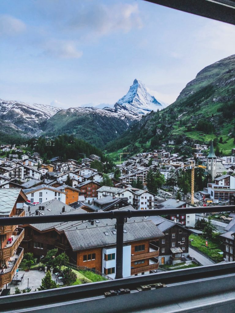 A student traverler's view of the cityscape of the mountain resort Zermatt with the iconic Matterhorn Mountain peak in the distance, located in Switzerland.