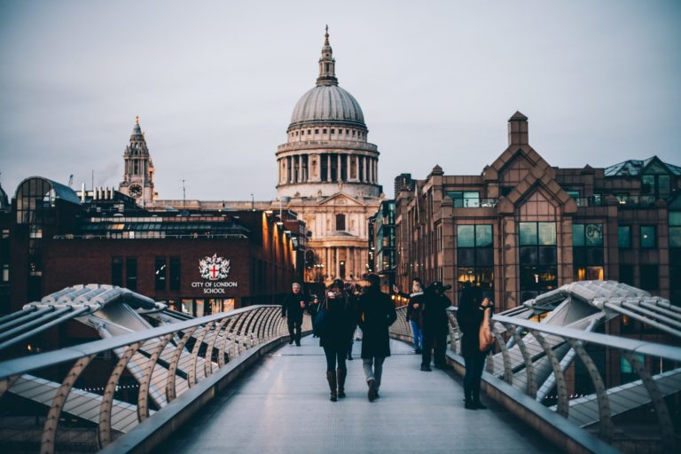 Student travelers walking the famous Millennium Bridge tour in London, UK.