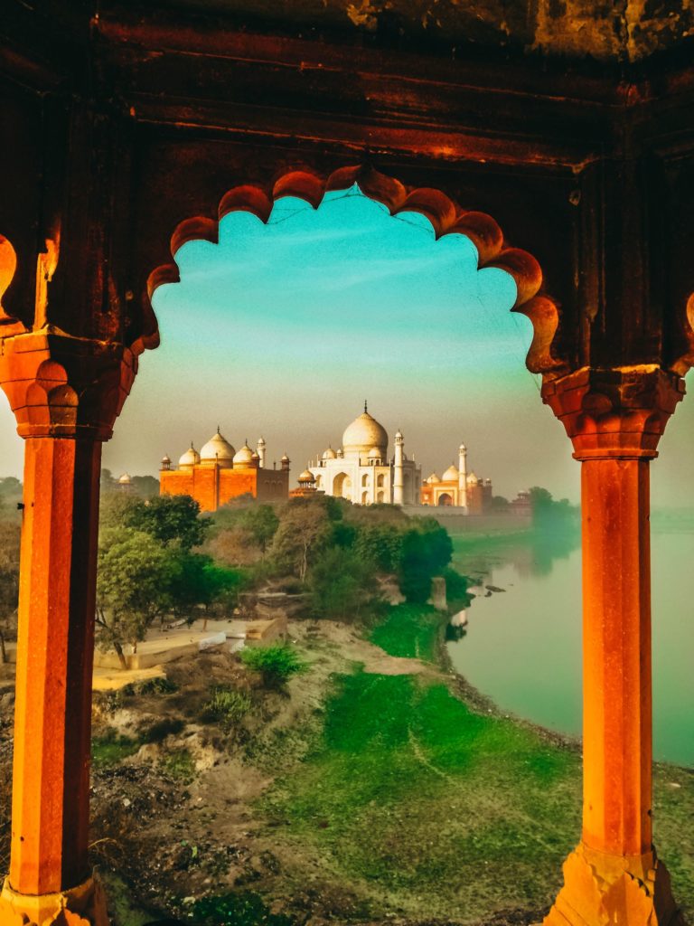 A student traveler framed the Taj Mahal with another building's pillars in Agra, India.