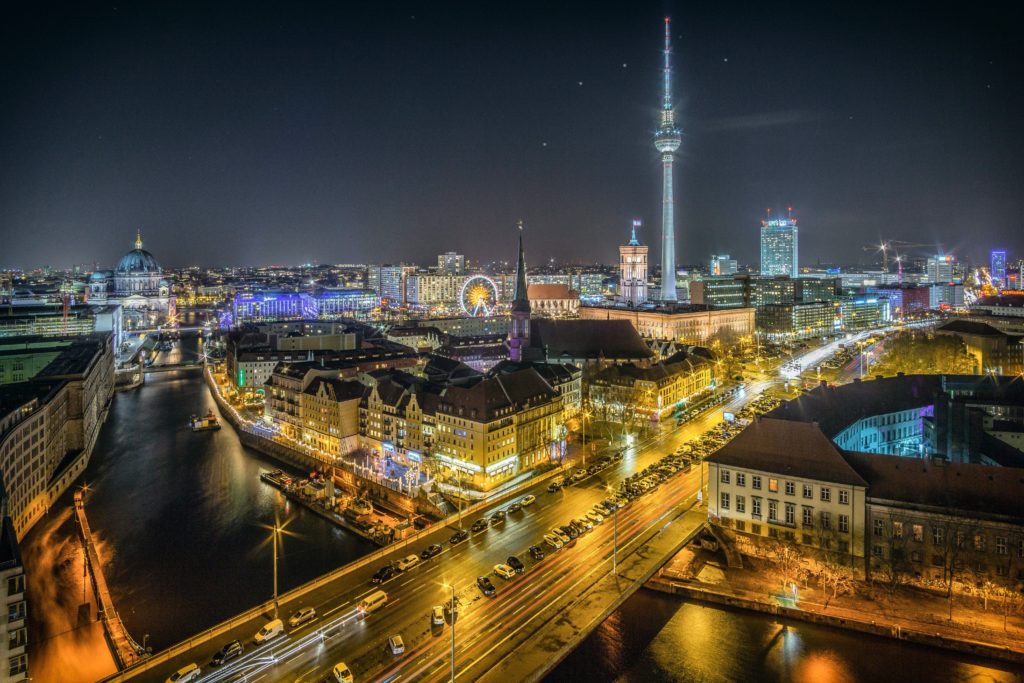 The city skyline of Berlin, Germany late at night, with the city glowing from lights from tourists traveling around the country alone. This image is featured in the Students Fare student travel blog, "Best Destinations for Solo Travelers," which lists places for individual tours.