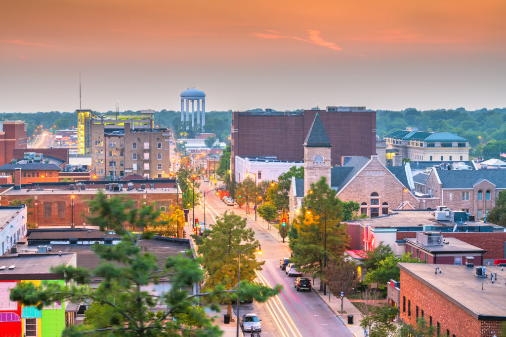 A beautiful small town, columbia, missouri, at sunset, with college buildings and modern city buildings. This image is featured in the Students Fare student travel blog, "Best College Towns in America," which describes the top university cities in the USA.