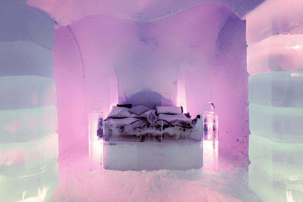 The honeymoon suite in the Sorrisniva Ice Hotel, in Norway, which has a bed carved from ice and purple mood lighting. This image is used in the Students Fare student travel blog, "Spring Break in Switzerland," which is a travel guide to celebrating spring vacation in the Swiss Alps.