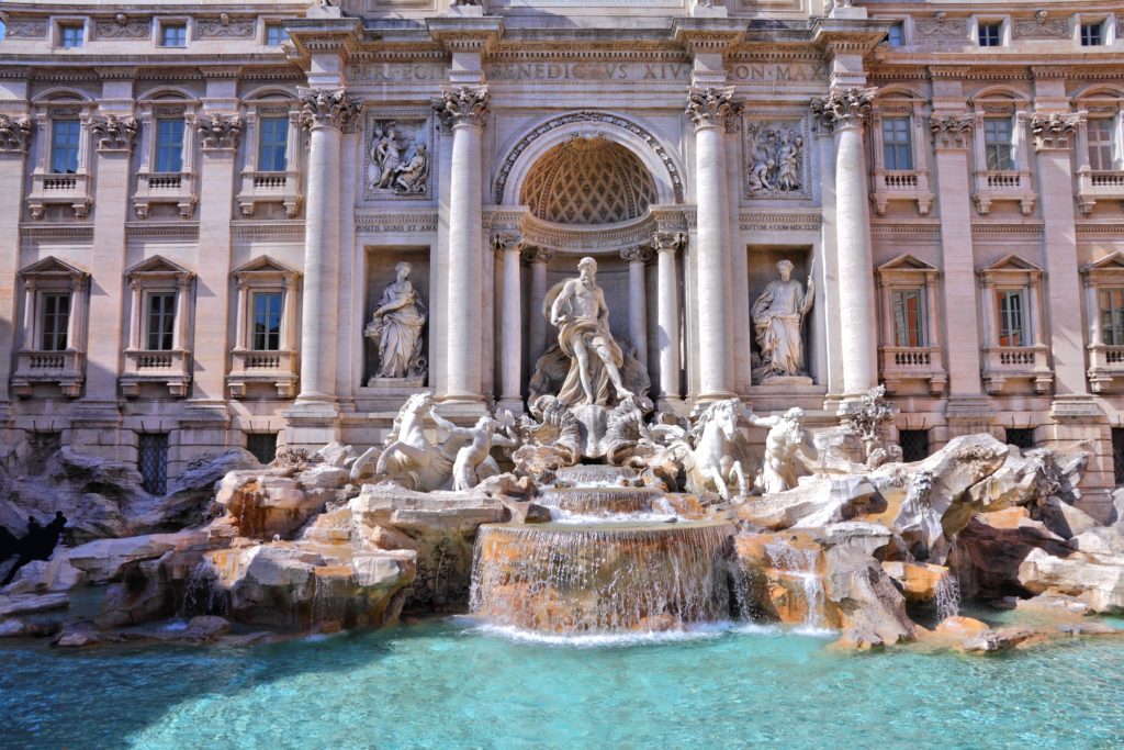 A shot of the Trevi Fountain in Rome, Italy, which is a beautiful white marble art sculpture with water elements to entertain solo travelers. This image is featured in the Students Fare student travel blog, "Best Destinations for Solo Travelers," which lists places for individual tours.