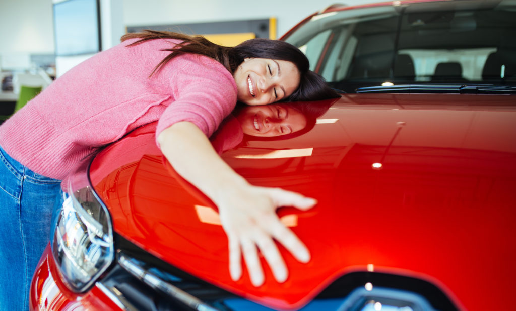 A young female student on vacation has rented a rental car, and purchased insurance to protect her wallet from being changed in an auto accident. This image is used in the Students Fare travel blog, "the ultimate travel insurance 101 guide," which describes travel insurance, its importance, and the various insurance options available.