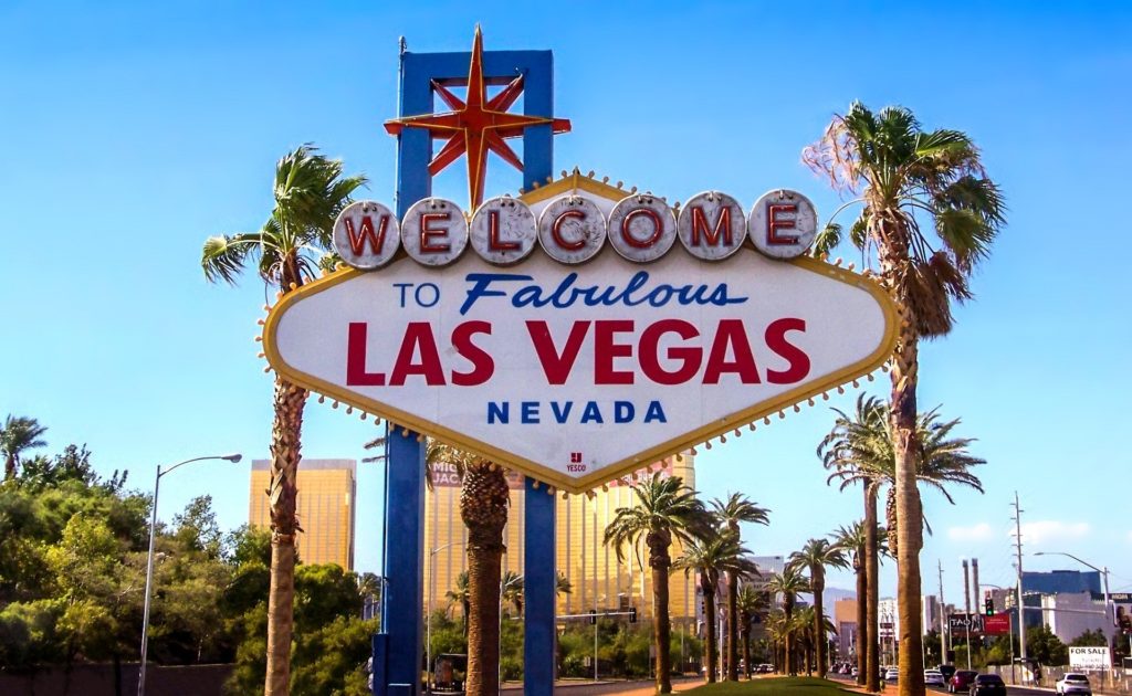 A large sign welcoming people to Las Vegas, Nevada with neon lighting on the Las Vegas Strip. This image is featured in the travel blog by Students Fare, "Best Destinations for Group Vacations," which lists the top locations for youth and student groups to travel!