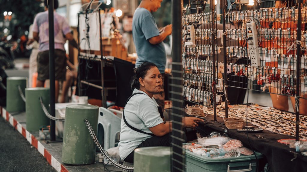 Featured in Tourist Scams to Avoid by Students Fare, this image shows a woman on the street selling jewelry.