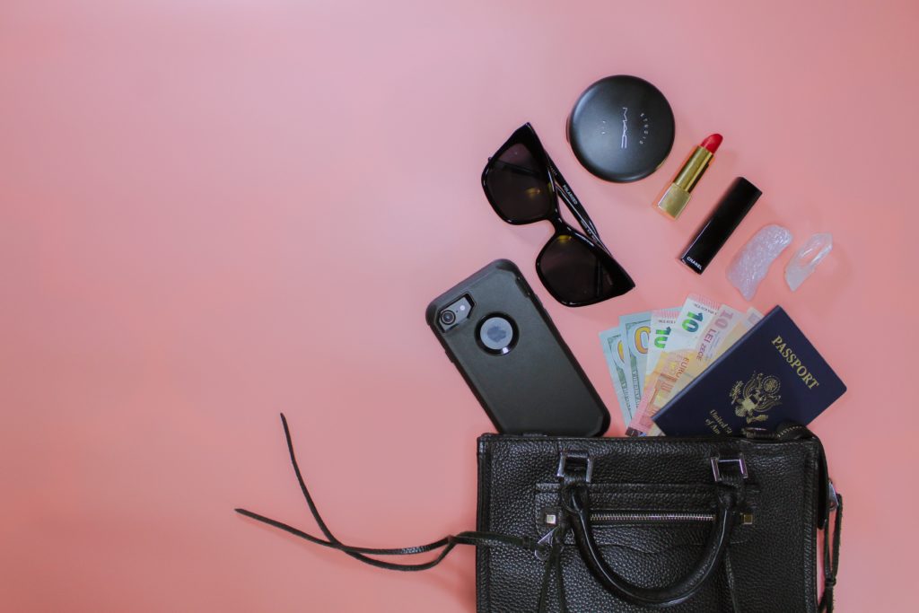 Featured in Packing Guide for Study Abroad by Students Fare, this image shows a purse with travel items meant for student travel.
