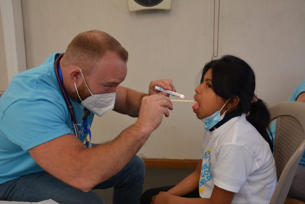 Featured in What Is A Volunteer Trip by Students Fare, this image shows doctors without boarders volunteering to help a young sick girl.