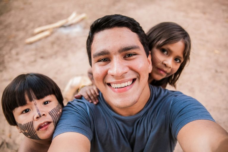 Featured in the Students Fare article, "Volunteering At The Amazon ," this image shows a volunteer with local children at the Amazon river basin.