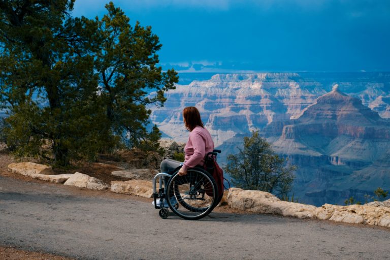 Featured in the Students Fare article, "Accessible Air Travel Guide," this image shows a female traveler using a wheelchair and viewing a gorgeous natural monument.