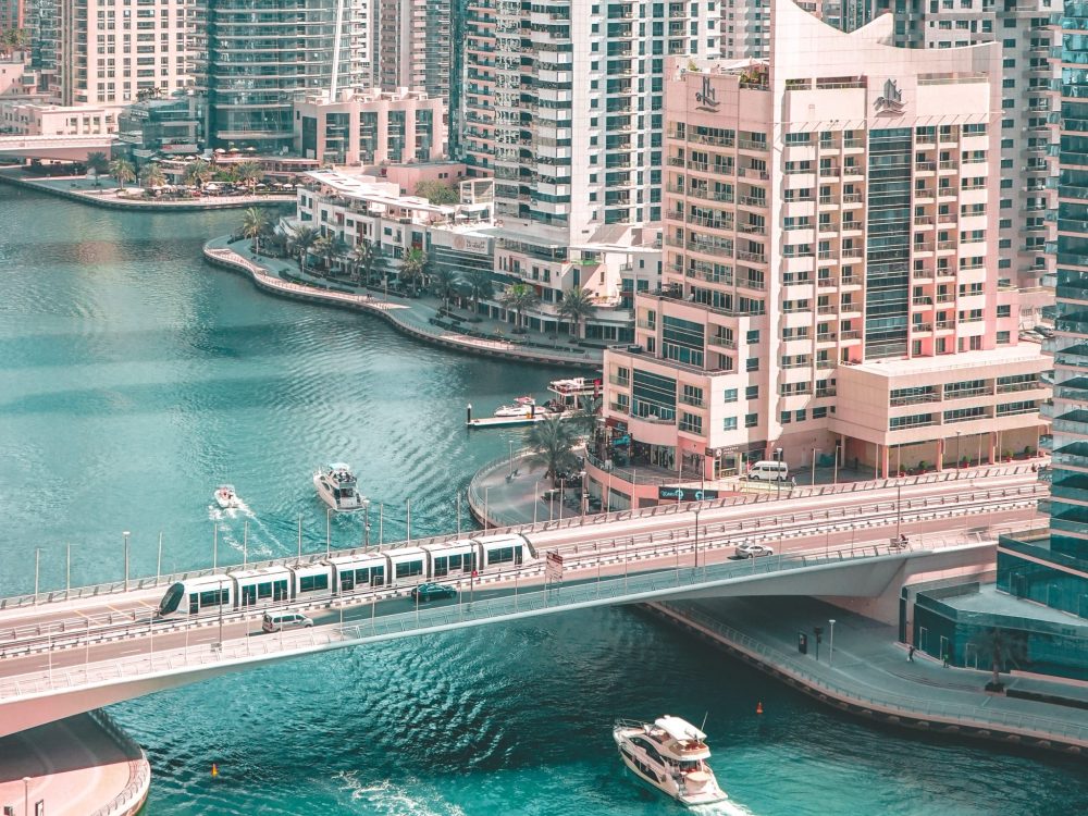 The Dubai Marina with boat tours going under the bridge in Dubai, United Arab Emirates.